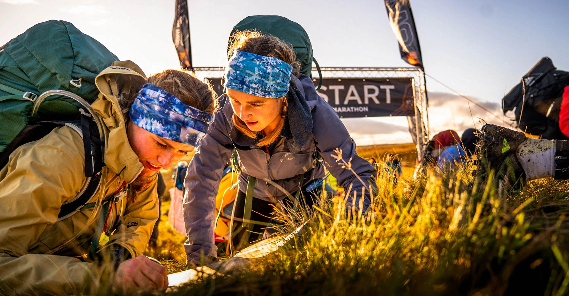 OMM competitors reading a map on a hillside at the start of the OMM