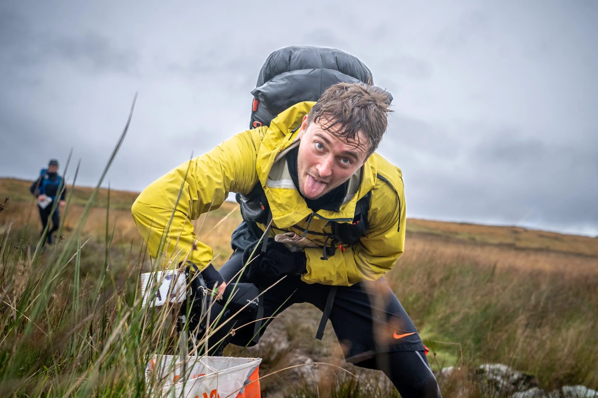 OMM competitor dibbing into a checkpoint and sticking their tongue out to the camera