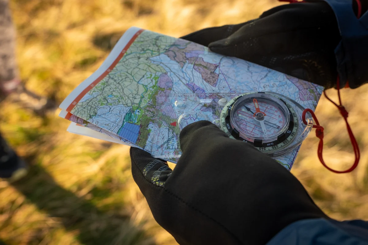 OMM competitors studying information at camp by headtorch