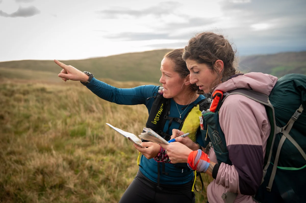Teams picking their route across an open mountainside