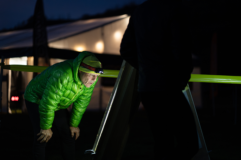 OMM competitor wearing a headtorch at the event centre after dark