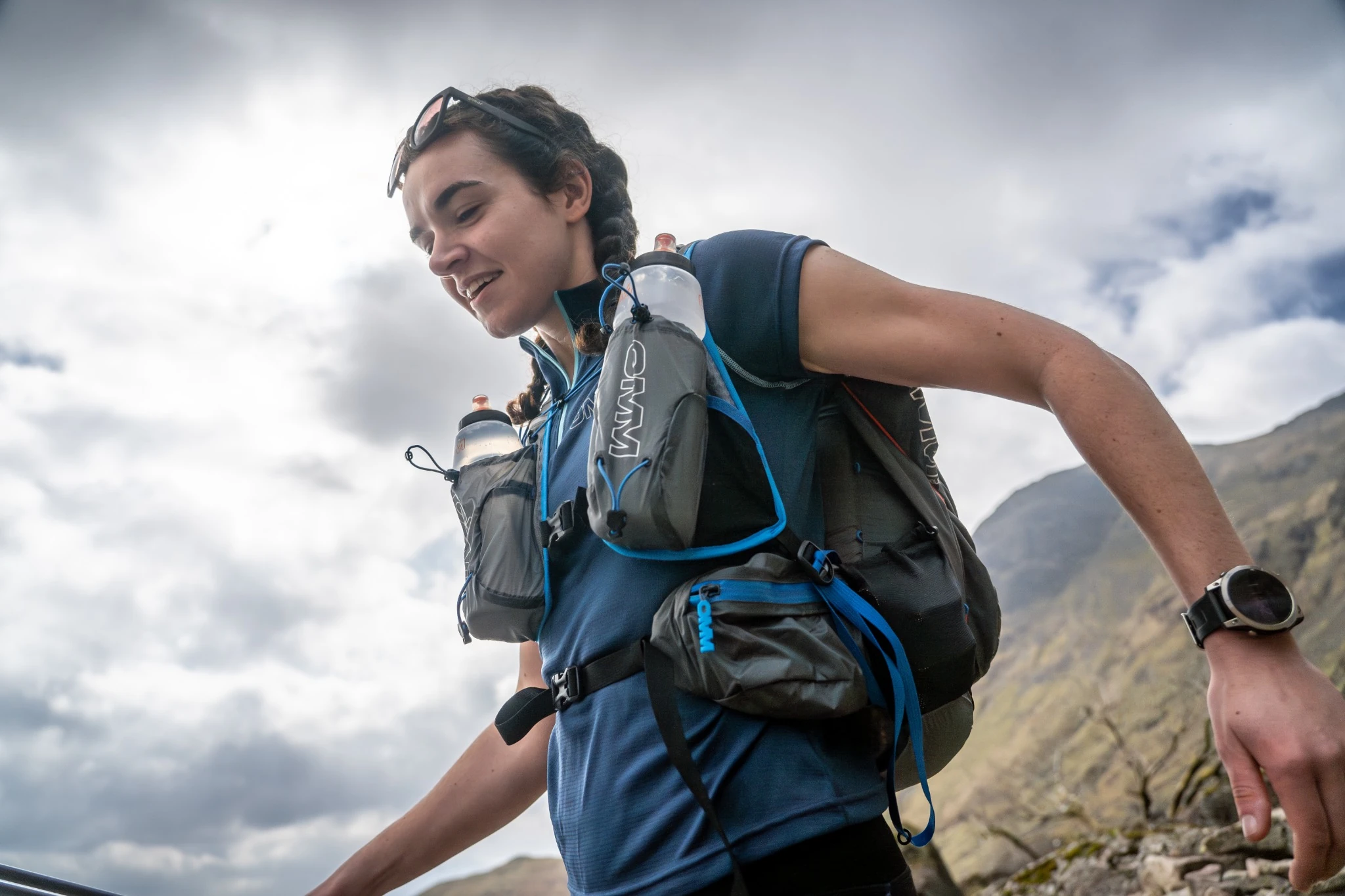 OMM runner carrying a pack and front-mounted water bottles