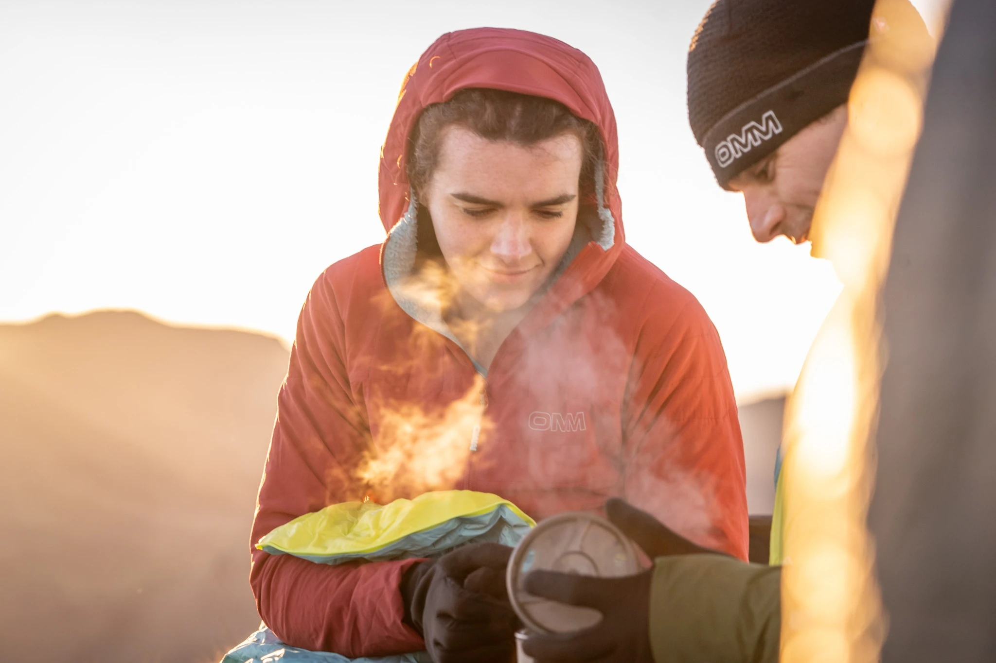 Competitors preparing food at camp in the evening light