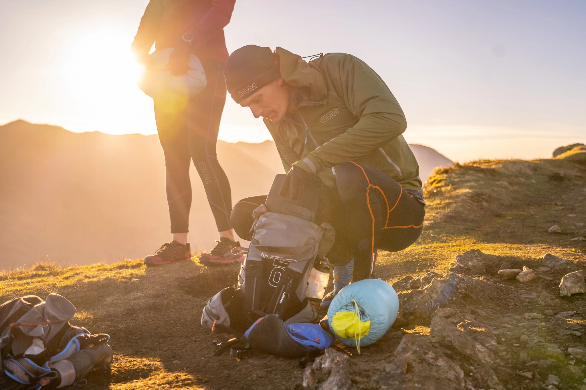 OMM competitor packing a rucksack in the evening sun